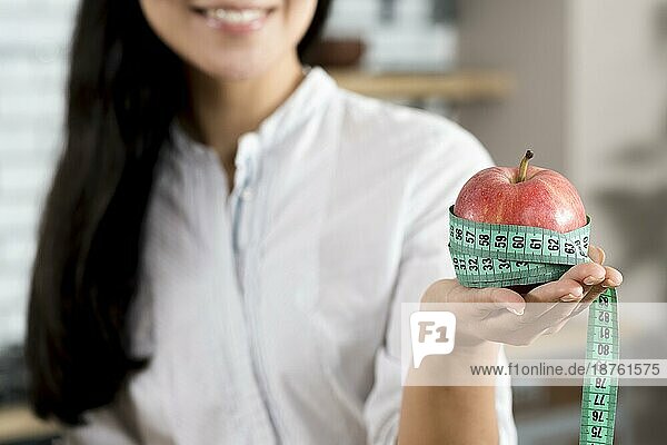 Close up Frau s Hand hält roten Apfel mit grünen Maßband