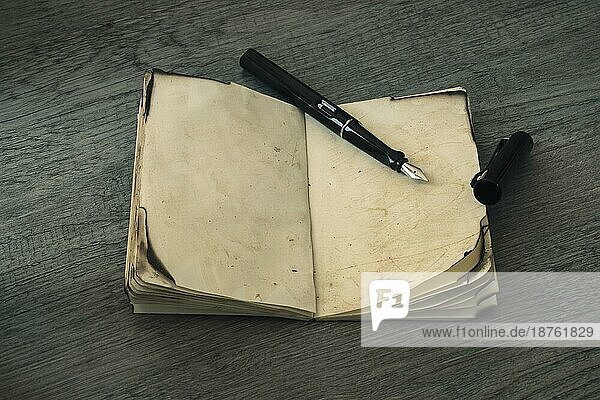 Tintenschreiber aufgeschlagenes altes Notizbuch