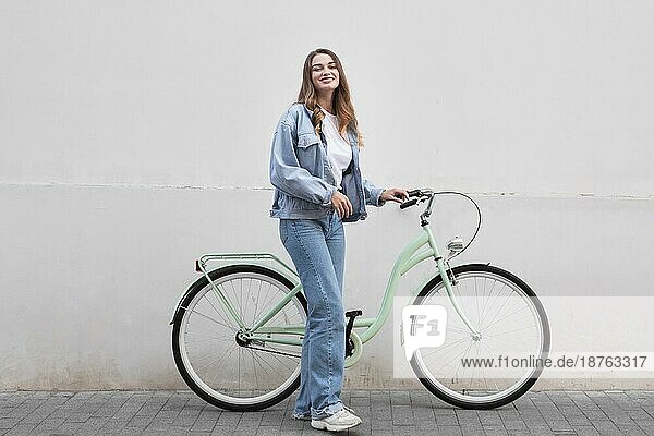 Frau posiert  während sie ihr Fahrrad im Freien hält Stadt