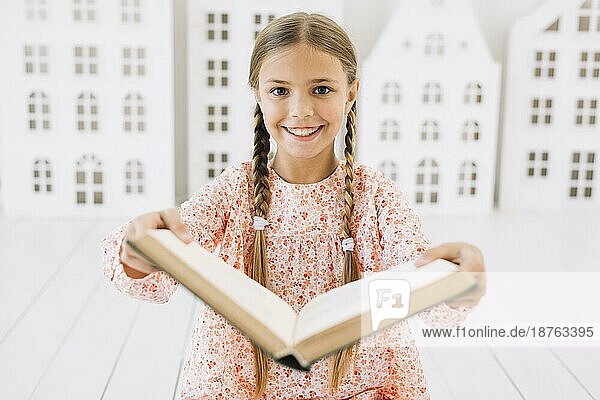 Schönes glückliches Mädchen posiert mit Buch