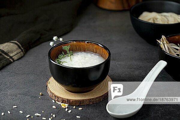 Reissuppe schwarze Schüssel hölzerne Unterstützung weißen Löffel . Auflösung und hohe Qualität schönes Foto