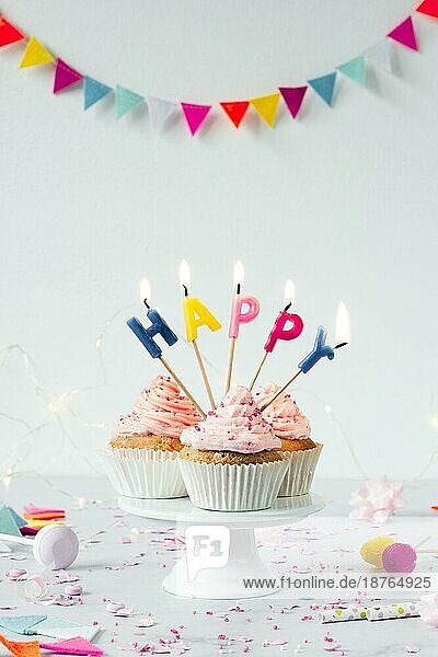 Vorderansicht Geburtstags-Cupcakes mit brennenden Kerzen