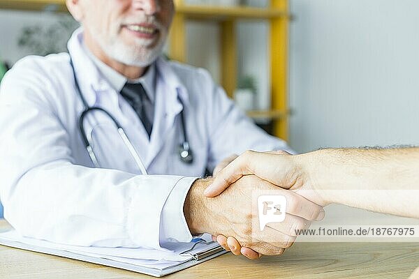 Lächelnder Arzt  der dem Patienten die Hand schüttelt