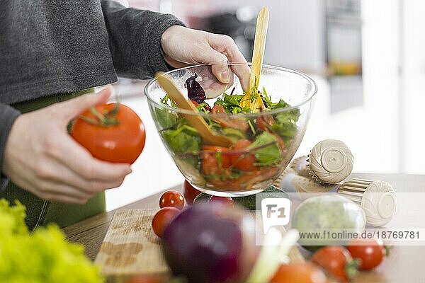 Hand hält Schüssel Salat. Foto mit hoher Auflösung