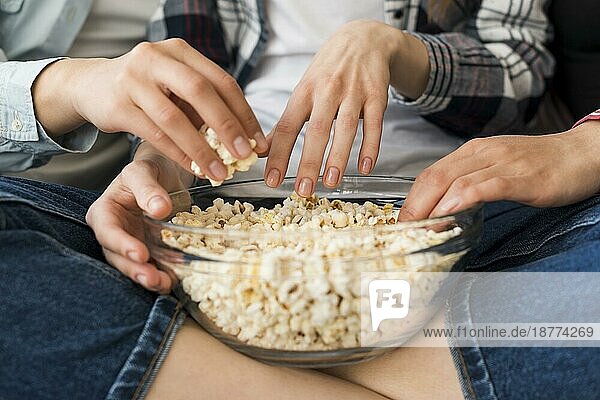 Schüssel mit Popcorn Hände Mädchen sitzt im Schneidersitz Sofa
