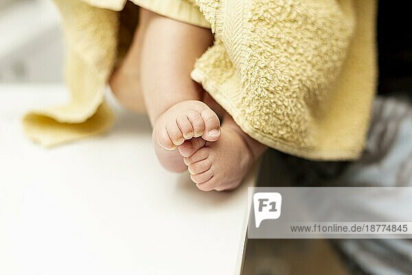 Nahaufnahme Babybeine mit gelbem Handtuch