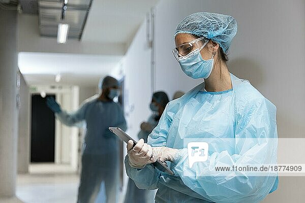 Arzt Schutzkleidung aussehen Tablette. Foto mit hoher Auflösung