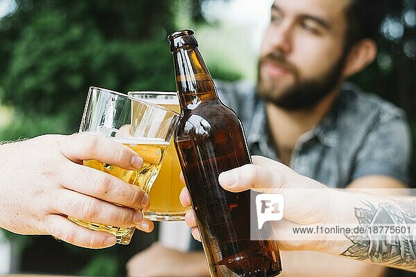 Männliche Freunde jubeln über alkoholische Getränke im Freien. Foto mit hoher Auflösung