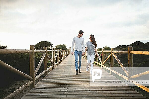 Verliebtes Paar geht Hand in Hand über die Brücke