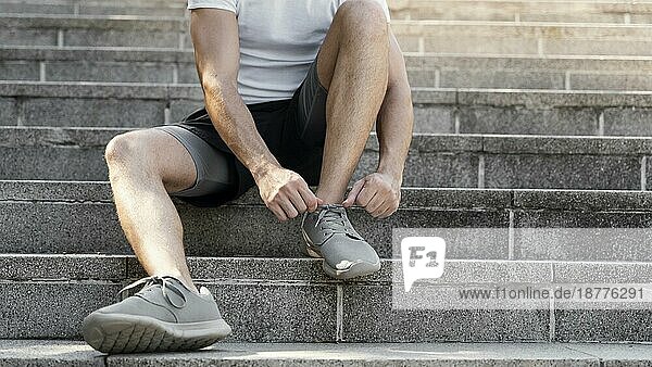 Vorderansicht Mann bindet ihre Schnürsenkel vor dem Training. Schönes Foto