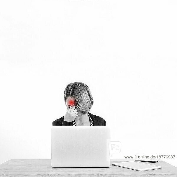 Frau mit Kopfschmerzen bei der Arbeit am Laptop