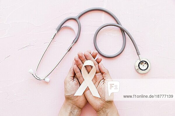 Weißes Bewußtsein Band zwei Hände mit Stethoskop rosa Hintergrund (1) . Auflösung und hohe Qualität schönes Foto
