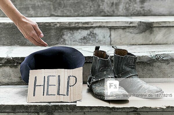 Obdachlose Person bettelt um Hilfe