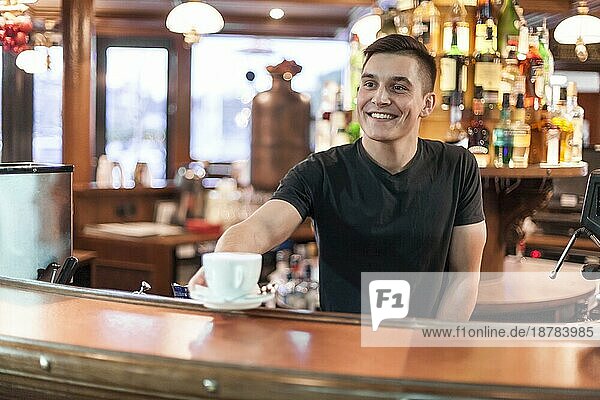 Lächelnde Barista schenkt Kaffee aus