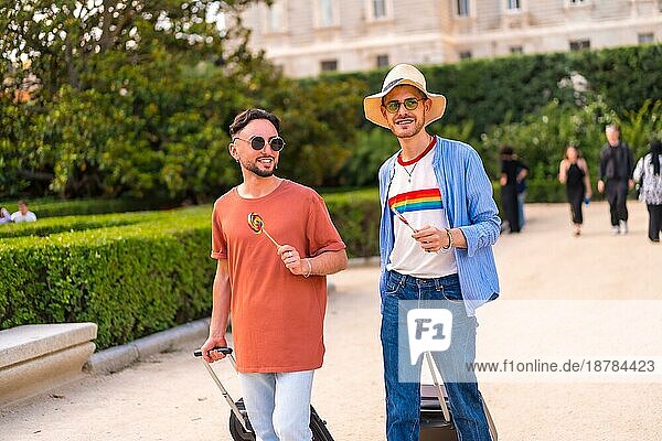 Männliche Touristen Homosexuell Freunde mit einem Koffer im Park auf Sonnenuntergang in der Stadt besuchen die Stadt. lgbt Konzept