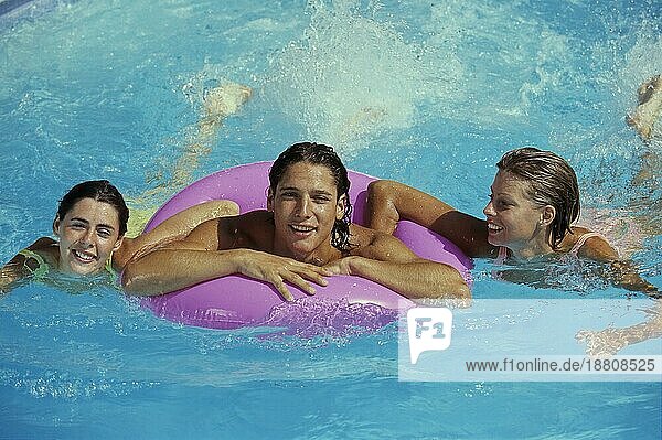3 junge Frauen im Wasser  1 Frau mit Schwimmring