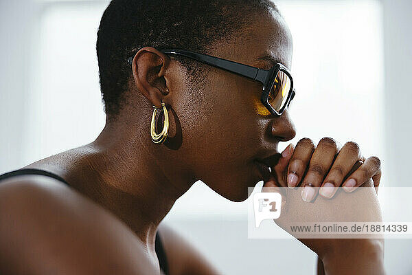 Thoughtful young woman with hands clasped