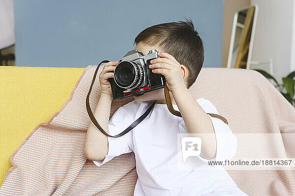 Boy photographing with vintage camera