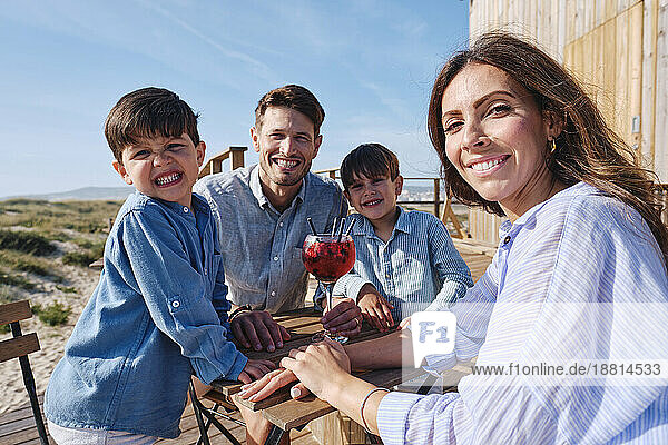 Glückliche Familie  die an einem sonnigen Tag zusammen am Tisch sitzt