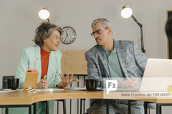 Älterer Geschäftsmann und Frau kommunizieren im Studio