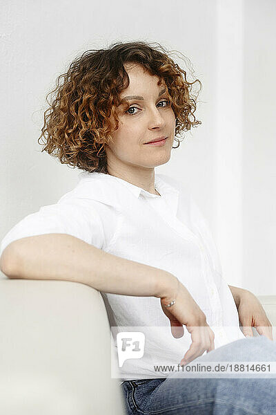 Woman with curly hair sitting on couch