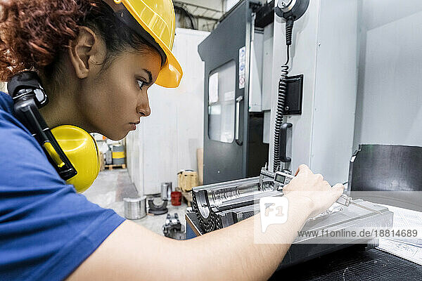 Maintenance engineer checking machine part in modern factory