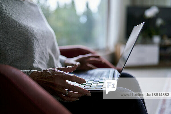 Ältere Frau benutzt Laptop zu Hause