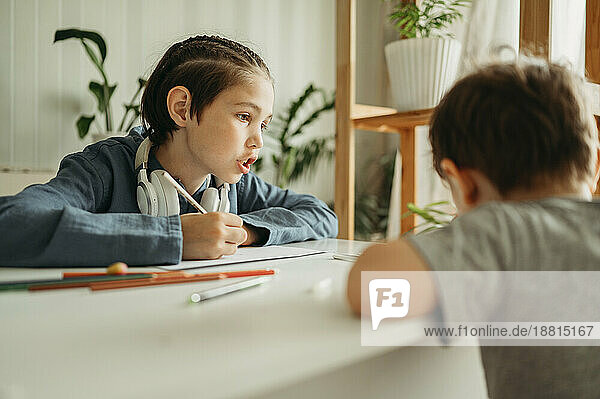 Boy talking to brother drawing at home