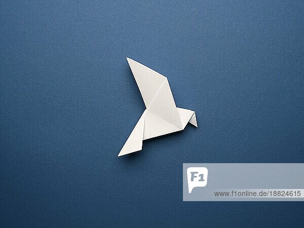 Weiße Origami Taube auf einem blaün Papierhintergrund  Frieden oder Freiheit Konzept  Papier Kunstwerk