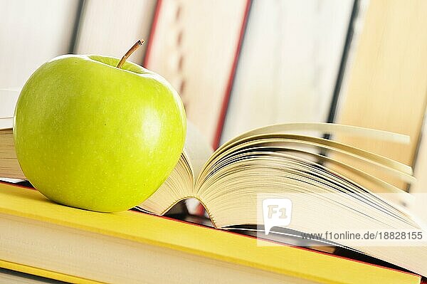 Komposition mit grünem Apfel und Büchern auf dem Tisch