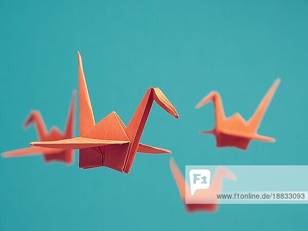 Vier Origami Kraniche auf einem blaün Hintergrund  Glück oder Erfolg Konzept