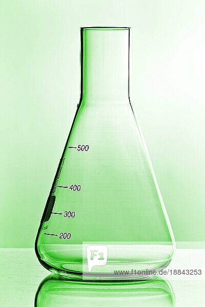 leeres grünes  chemieglas vor neutralem hintergrund