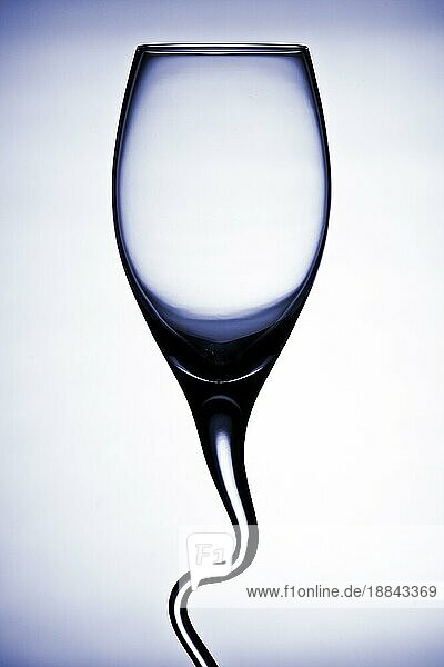 geschwungenes Weinglas kontrastreich vor weißem Hintergrund