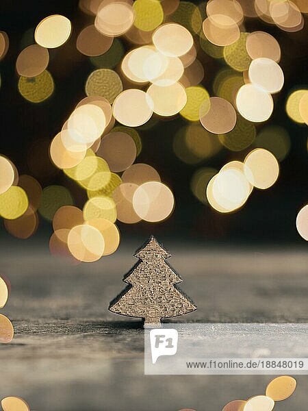 Kleine hölzerne Baumform mit verschwommener Weihnachtsbeleuchtung  traditioneller Weihnachtskartenhintergrund  mit Platz für Text
