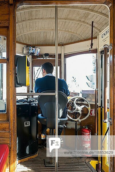 Innenansicht einer historischen Straßenbahn mit Fahrer  in den Straßen von Lissabon