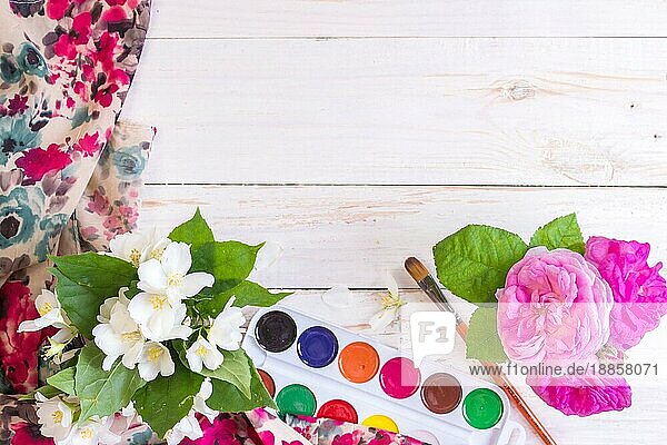 Schreibtisch eines kreativen Arbeiters. Farben  Pinsel und Blumen. Ansicht von oben Hintergrund