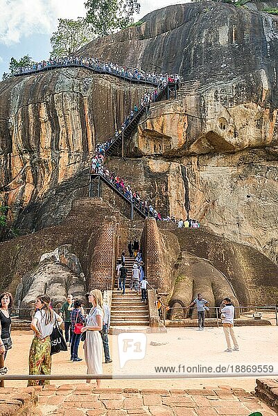 Große Pfoten am Löwentor der Felsenfestung Sigiriya. Fußgänger auf der Kletterstrecke  die zu den Palastruinen führt