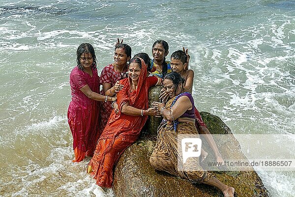 Touristen genießen das Baden im Meerwasser am Zusammenfluss der drei Meere Golf von Bengalen  Arabisches Meer und Indischer Ozean in Kanyakumari  Tamil Nadu  Südindien  Indien  Asien