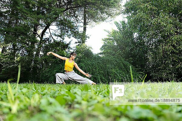 Frau beim Üben von Tai Chi Chuan im Freien. Tai Chi Praktiken können dazu beitragen  die Flexibilität  die Kraft und das Gleichgewicht des Körpers zu verbessern sowie Stress und Ängste abzubauen