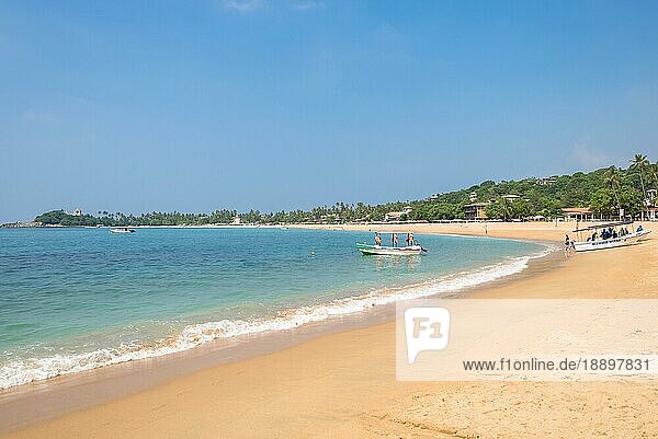Am Strand von Unawatuna  einem der wichtigsten Touristenorte im Südwesten Sri Lankas  in der Nähe von Galle. Touristen nehmen ein Sonnenbad  entspannen sich und treiben Wassersport