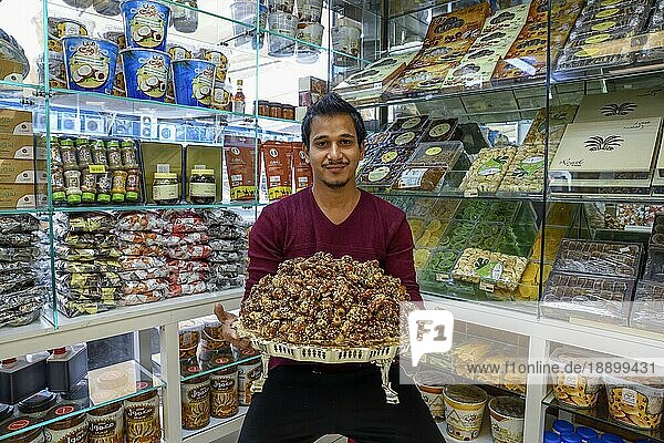Verkäufer mit einer Schale Datteln  Dattelmarkt  Abu Dhabi-Stadt  Emirat Abu Dhabi  Vereinigte Arabische Emirate  Asien