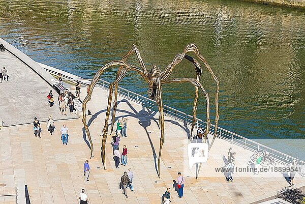 Die Maman Skulptur aus Bronze und rostfreiem Stahl der Künstlerin Louise Bourgeois in der Stadt Bilbao. Stadtbewohner  Touristen  Menschen genießen den sonnigen Tag an der Nervion Brücke