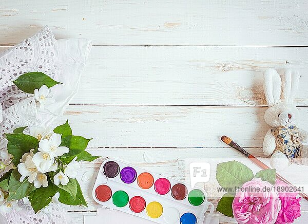 Schreibtisch eines kreativen Arbeiters. Farben  Pinsel und Blumen. Ansicht von oben Hintergrund