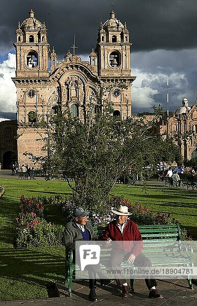 Männer auf einer Parkbank sitzend  Plaza de Armas in Cuzco  Iglesia de la Compania de Jesus Church  Peru  Südamerika