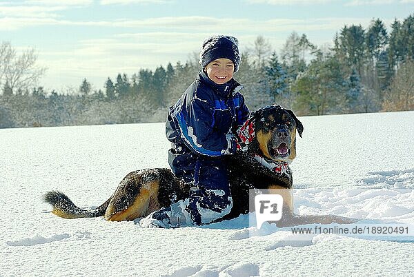 Junge mit Mischlingshund  Skianzug  Mütze