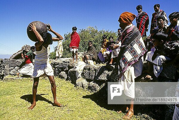 Toda's Youngman hebt mit Stolz und Freude einen großen kugelförmigen Stein und legt ihn für einige Zeit auf die Schulter in Kinnakorai  Nilgiris  Ooty Udhagamandalam  Tamil Nadu  Südindien  Indien  Asien