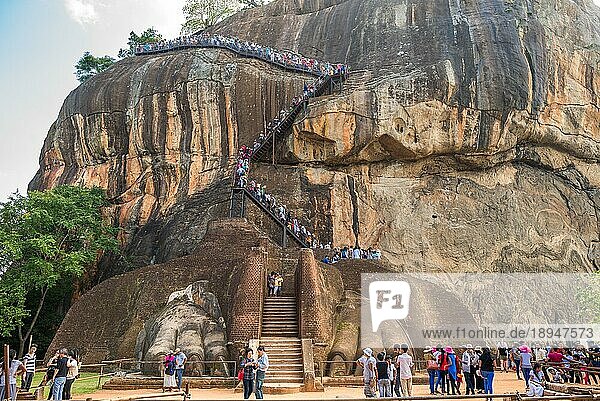 Große Pfoten am Löwentor der Felsenfestung Sigiriya. Fußgänger auf der Kletterstrecke  die zu den Palastruinen führt
