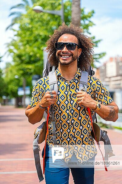 Lächelnder Backpacker Afrohaar Mann im Sommerurlaub  Lebensstil außerhalb eines Touristen auf Reisen