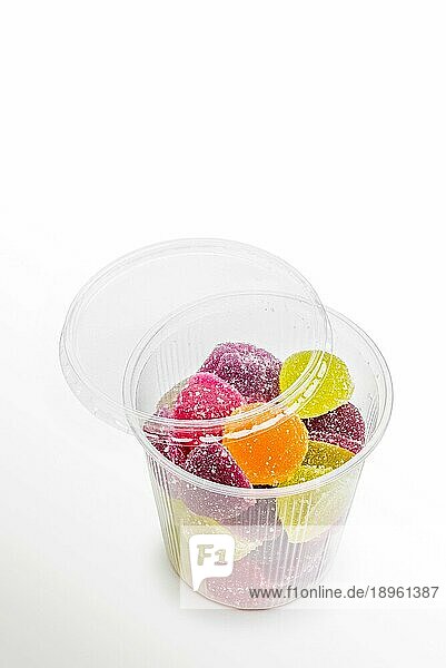 Buntes Fruchtgelee in offenem Schaumglas  auf weißem Hintergrund