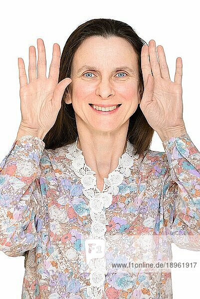 Lächelnde Frau mit offenen blaün Augen und offenen Händen  die die Handflächen dicht am Gesicht zeigen